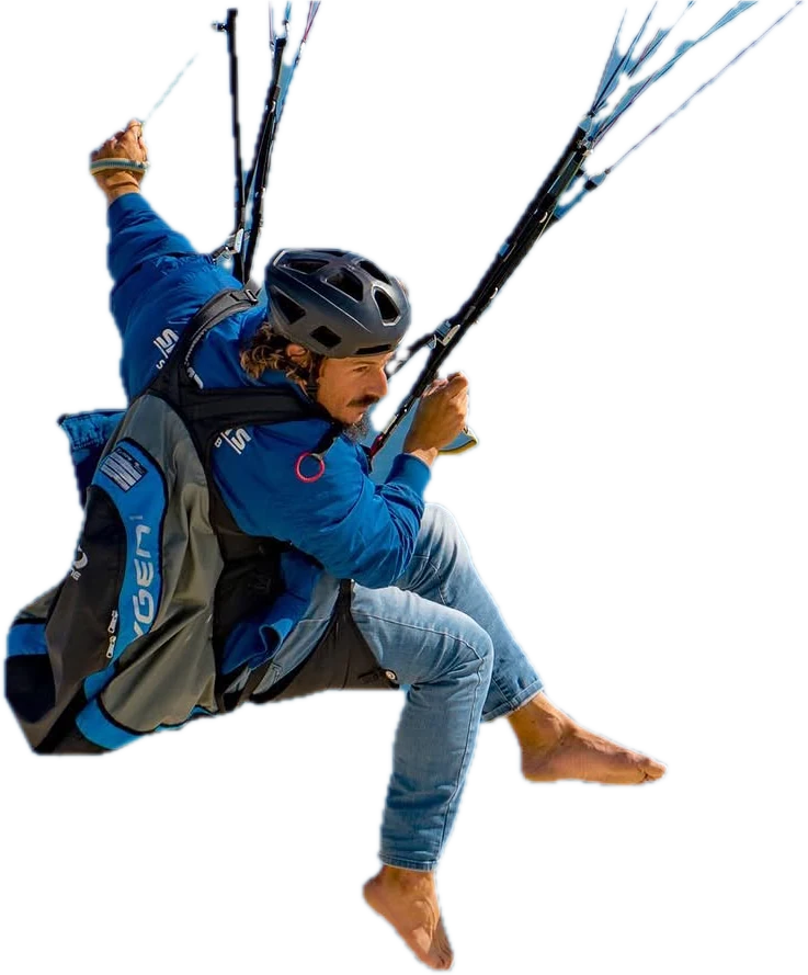 Javi Tejeiro in a pod harness, helmet on, legs kicked out barefoot, looking down at the ground far below