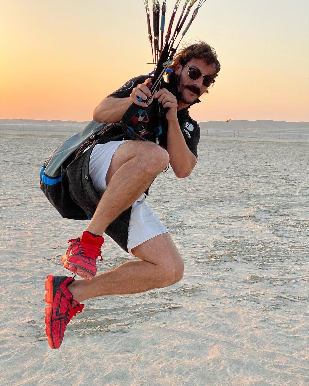 Javi tucked mid-air at sunset on the sand flats, hands on the risers